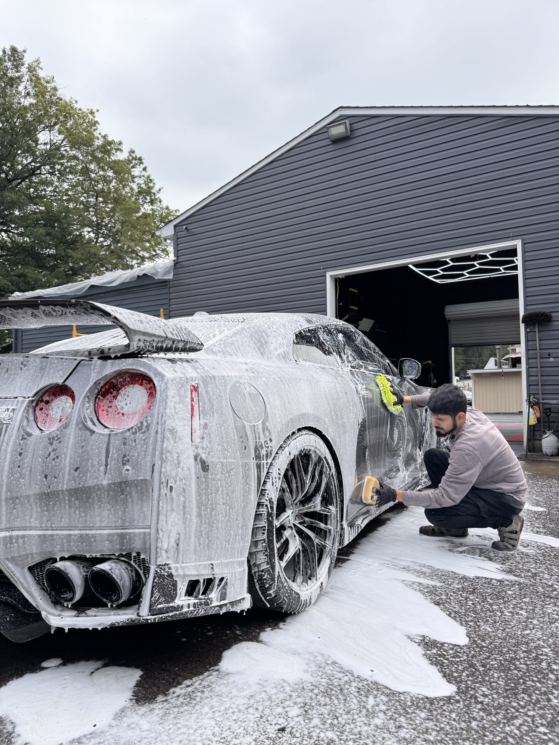 A sports car covered in foam during exterior detailing